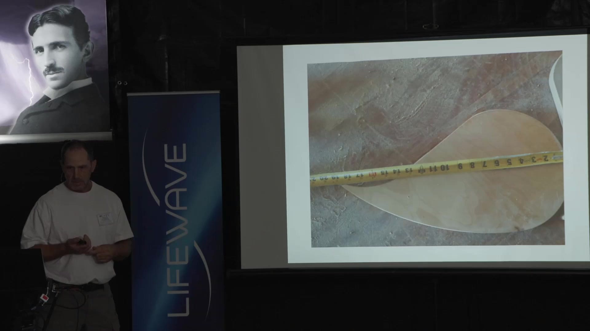 Terry McMenomy shows a fabricated turbine blade measured against a tape measure