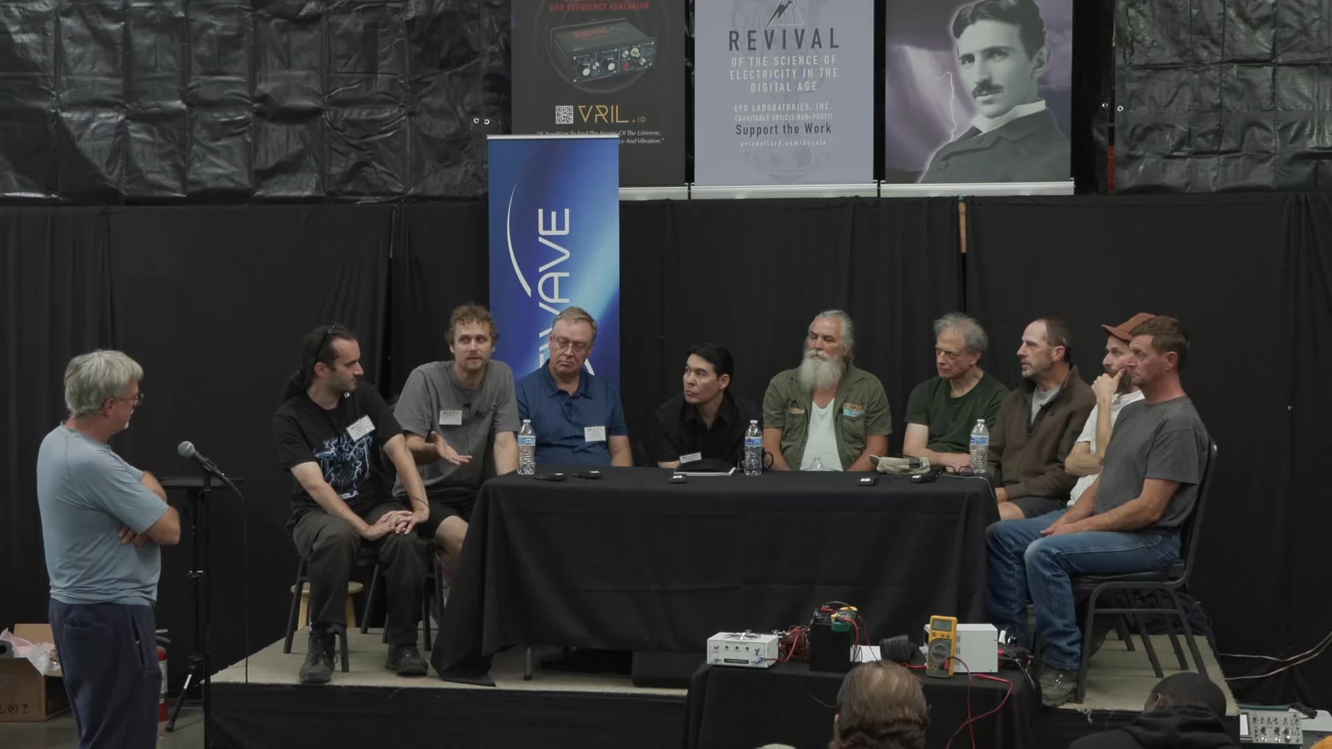 An audience member at the floor microphone questions the panel