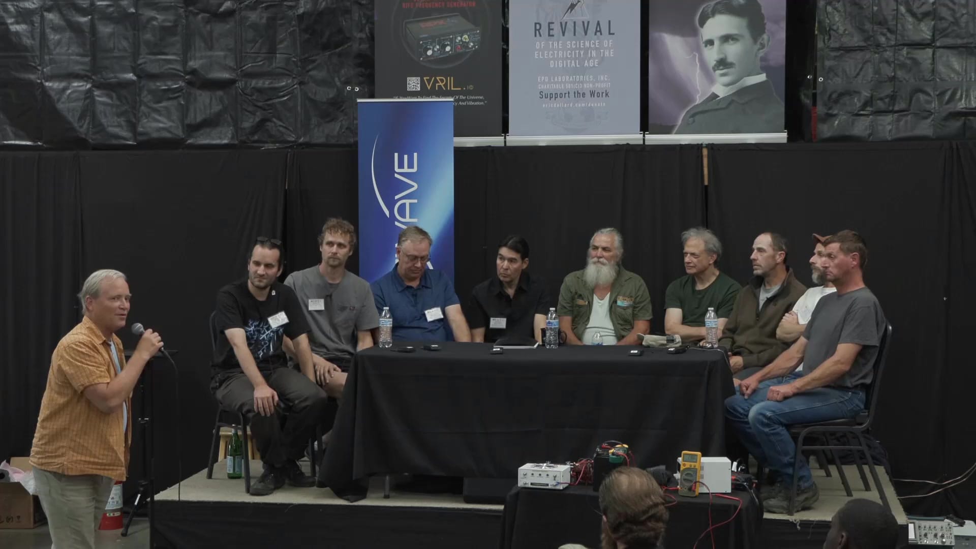 Another audience member at the microphone puts a question to the full panel